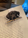 Black labrador magnetic bookmark clipped onto an open paperback book