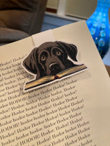 Black labrador magnetic bookmark clipped onto an open paperback book