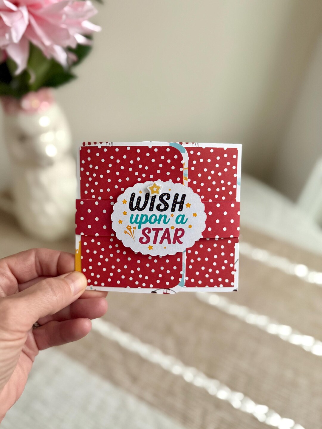 Pop-up gift bag detail with red polka-dot pattern and 'Wish Upon a Star' label