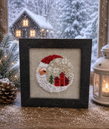 Framed cross-stitch — Santa Christmas Village, dark brown frame close-up