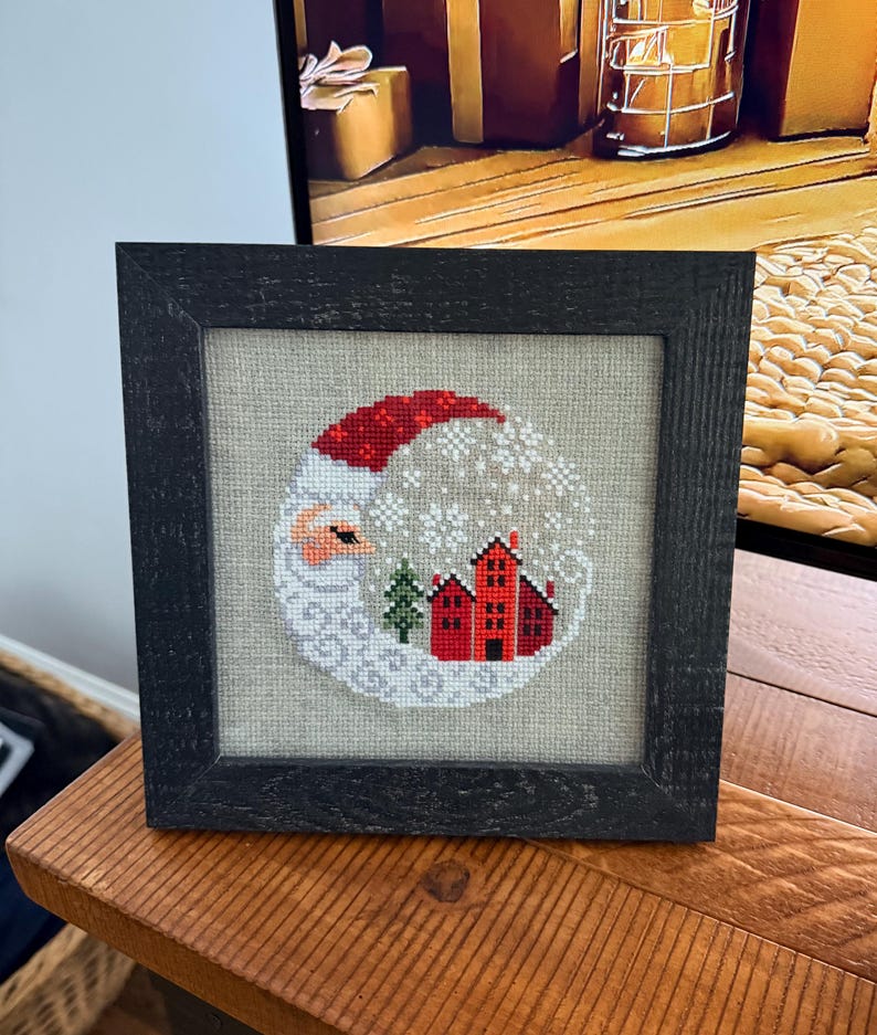 Framed cross-stitch — Santa Christmas Village, distressed black frame