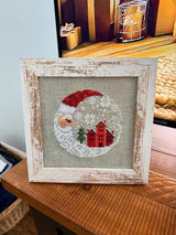 Framed cross-stitch — Santa Christmas Village, distressed white frame detail