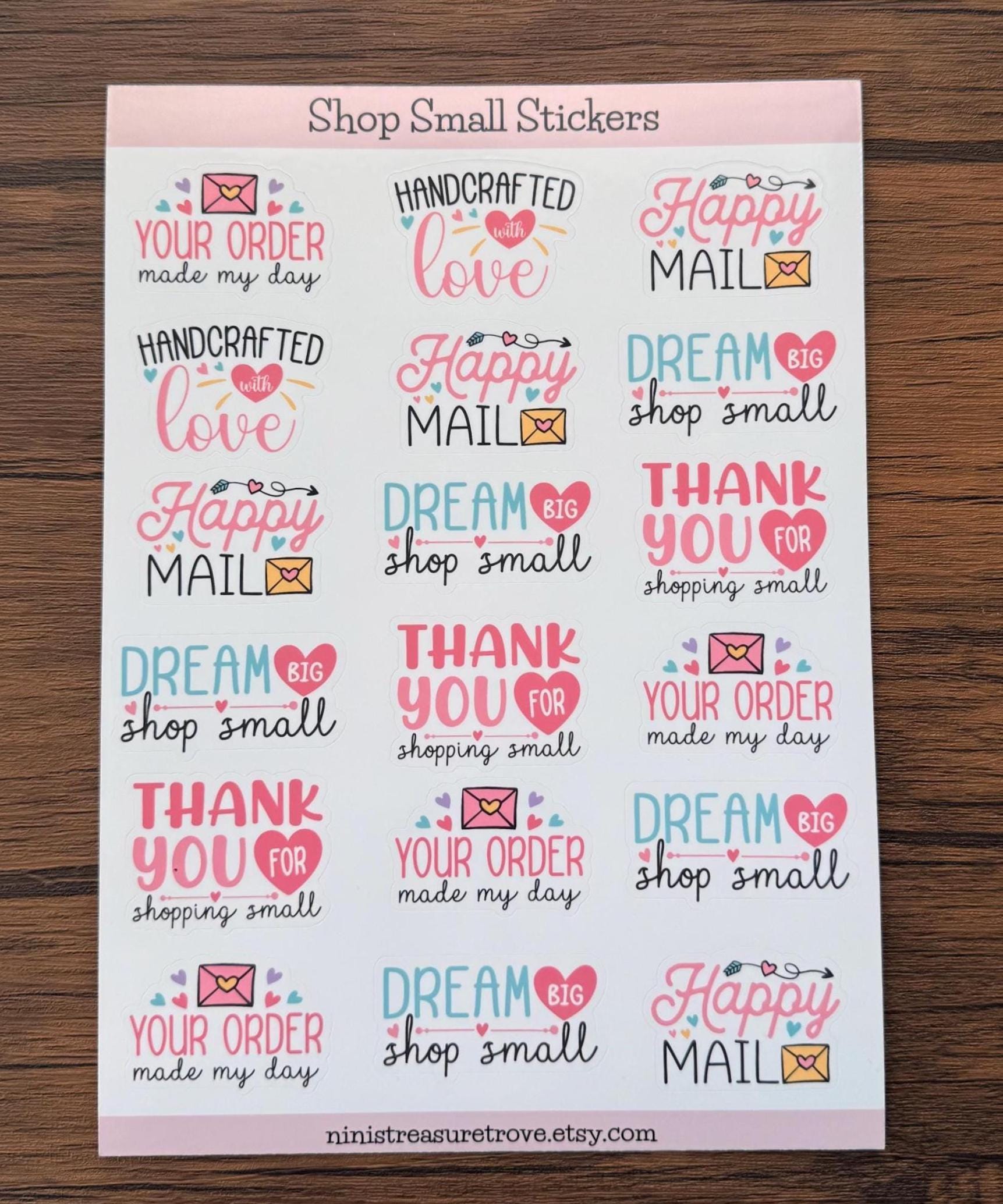 Flat-lay of the Happy Mail thank-you sticker sheet on a wooden surface, showing 18 hand-illustrated small-business stickers